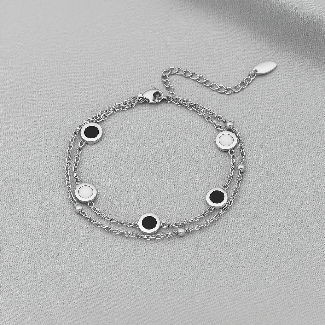 Pulseras blancas y negras en capas