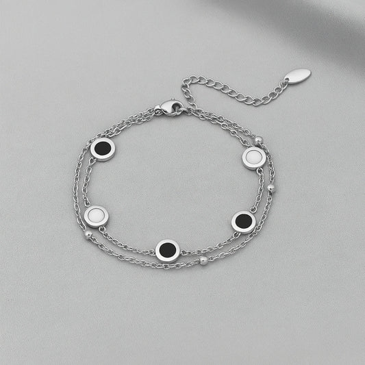 Pulseras blancas y negras en capas